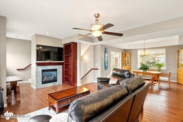 18627 Mountain Plover Cir, Anchorage, AK 99516 - living area with wood finished floors, ceiling fan, a tiled fireplace, and recessed lighting