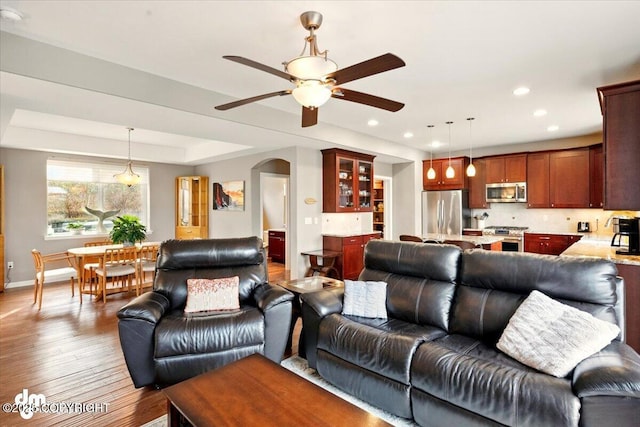 18627 Mountain Plover Cir, Anchorage, AK 99516 - living room featuring a ceiling fan, wood finished floors, recessed lighting, and arched walkways