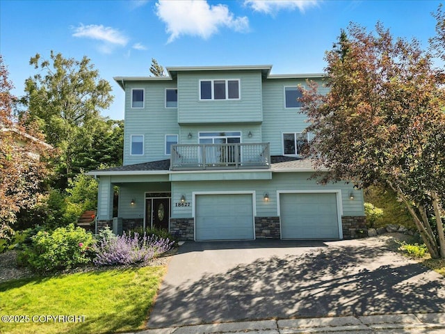 18627 Mountain Plover Cir, Anchorage, AK 99516 - view of front facade featuring driveway, a balcony, a garage, and stone siding
