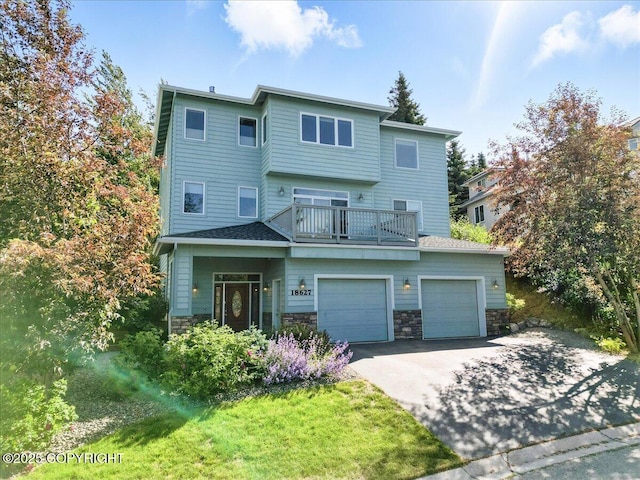 18627 Mountain Plover Cir, Anchorage, AK 99516 - view of front of home featuring asphalt driveway, stone siding, a garage, and a balcony