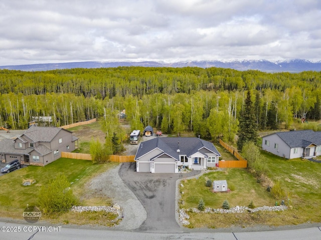 aerial view of property and surrounding area featuring a heavily wooded area