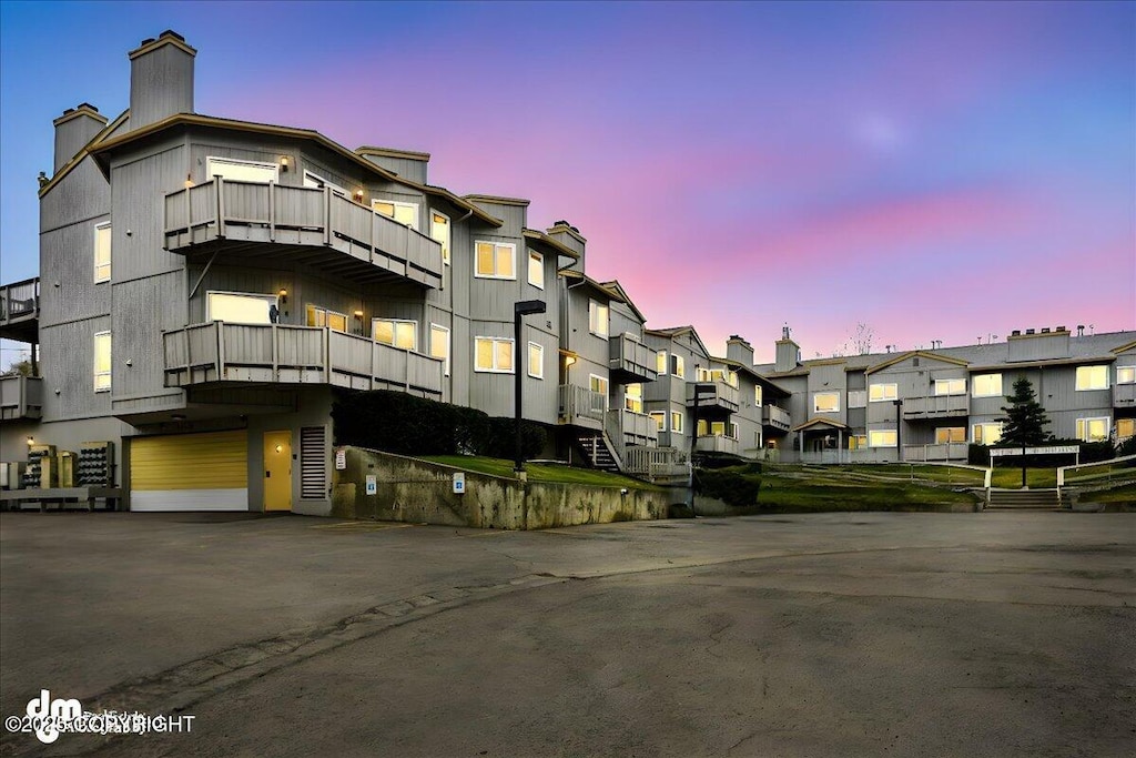 4109 Lynn Dr # 202, Anchorage, AK 99508 - property at dusk with an attached garage, a residential view, and driveway