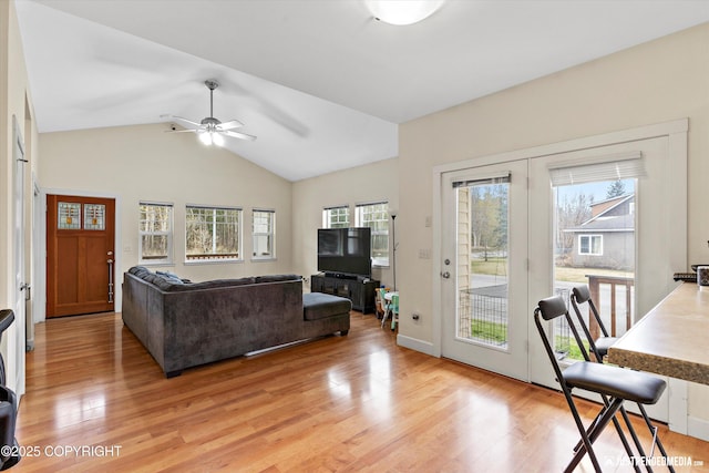 living area with light wood-style floors, a ceiling fan, and lofted ceiling