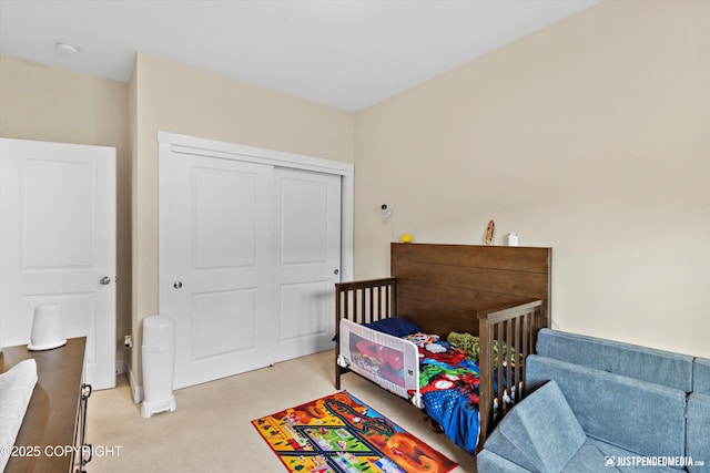 bedroom featuring light colored carpet and a closet