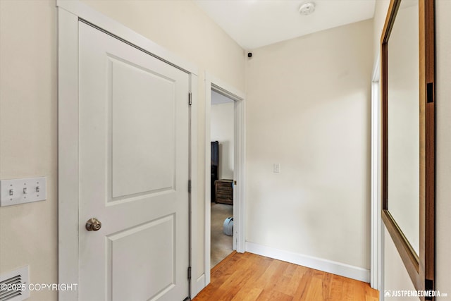 hall featuring light wood finished floors and baseboards