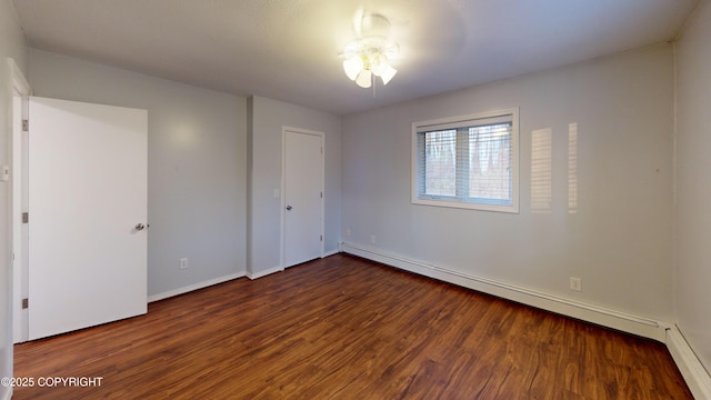 unfurnished bedroom with baseboards, baseboard heating, and wood finished floors