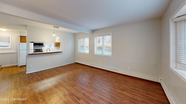 unfurnished living room with baseboards, a baseboard radiator, a sink, and wood finished floors