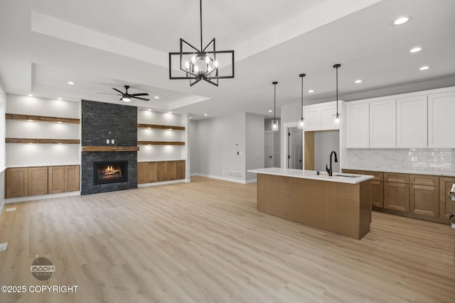 kitchen with recessed lighting, a sink, light wood-style flooring, a ceiling fan, and backsplash