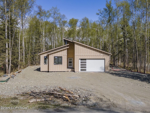 detached garage featuring a forest view