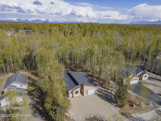 aerial view of property and surrounding area featuring a heavily wooded area