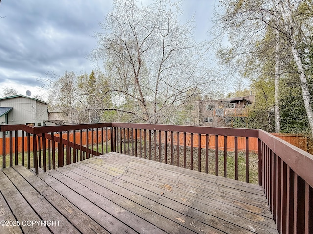 wooden terrace with a fenced backyard
