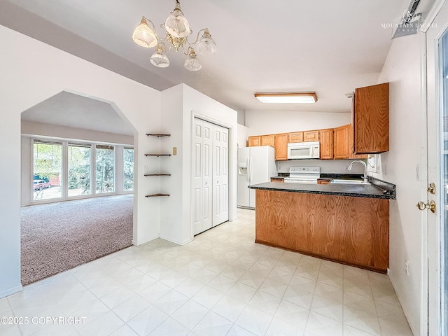 kitchen featuring white appliances, a sink, lofted ceiling, dark countertops, and light floors