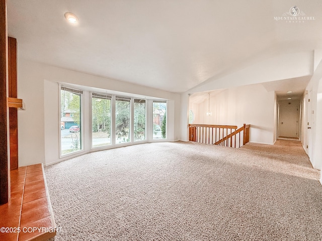 carpeted spare room featuring lofted ceiling
