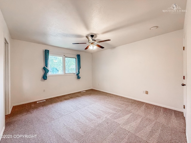 empty room featuring ceiling fan, carpet, and baseboards