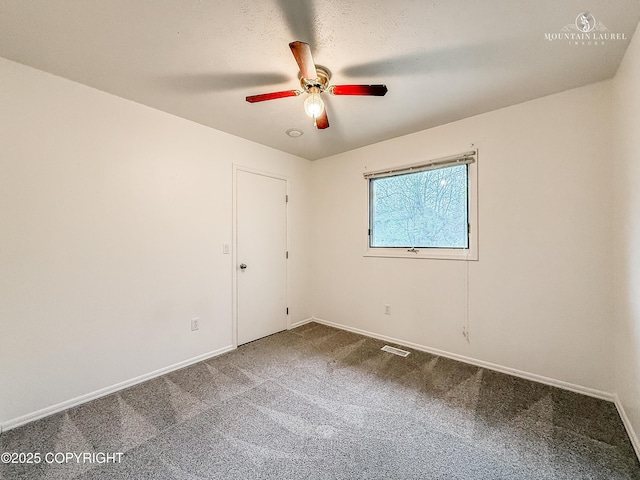 carpeted empty room with ceiling fan and baseboards