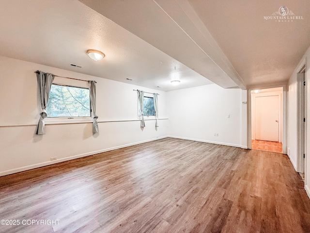 spare room with wood finished floors and baseboards