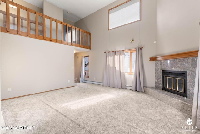unfurnished living room with a fireplace, carpet, a high ceiling, and baseboard heating
