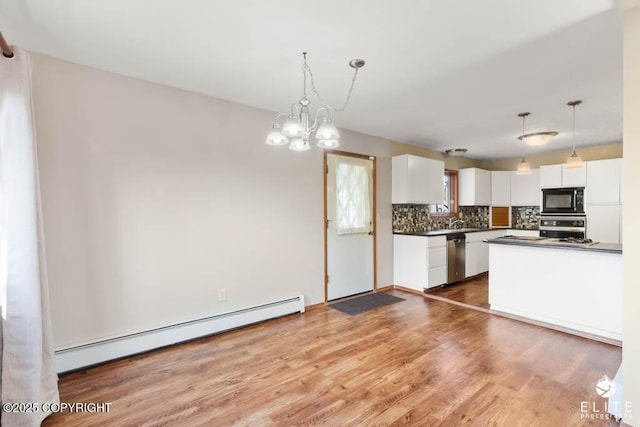 kitchen featuring a baseboard radiator, decorative backsplash, white cabinets, dark countertops, and appliances with stainless steel finishes