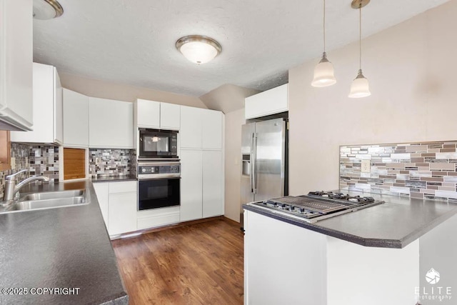 kitchen featuring decorative light fixtures, decorative backsplash, stainless steel appliances, and a sink