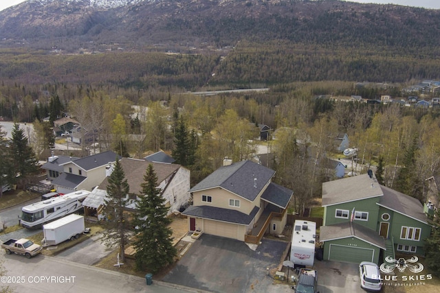 birds eye view of property with a residential view, a mountain view, and a view of trees