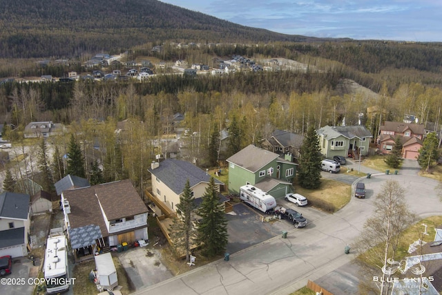 drone / aerial view with a mountain view, a residential view, and a view of trees