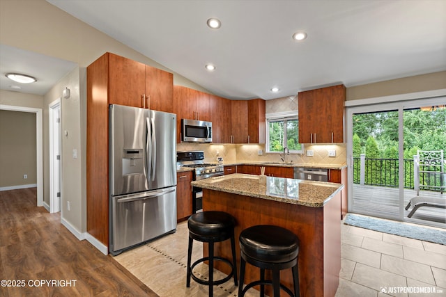 3520 Glenn-Don Cir, Anchorage, AK 99504 - kitchen featuring stainless steel appliances, tasteful backsplash, light stone countertops, a breakfast bar area, and recessed lighting