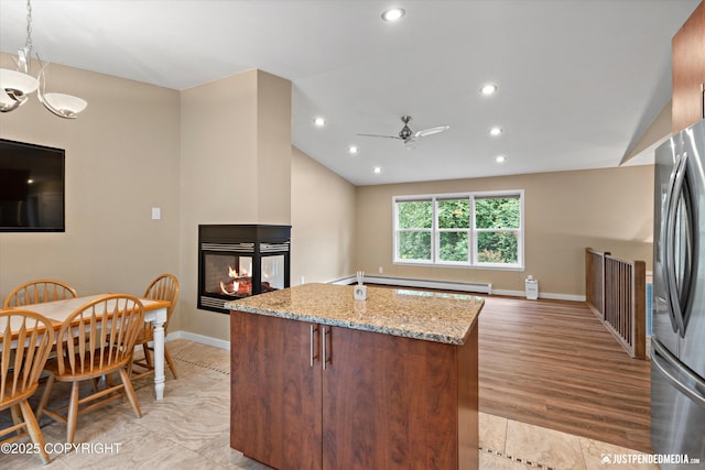 3520 Glenn-Don Cir, Anchorage, AK 99504 - kitchen featuring a baseboard heating unit, vaulted ceiling, a multi sided fireplace, freestanding refrigerator, and light stone countertops