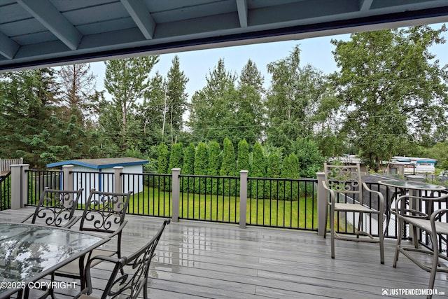 3520 Glenn-Don Cir, Anchorage, AK 99504 - wooden terrace with outdoor dining area, a storage shed, view of wooded area, and a yard