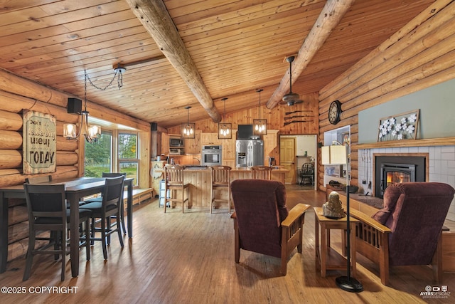 265 Ames Rd, Kenai, AK 99611 - living room with log walls, hardwood / wood-style floors, wooden ceiling, and a tile fireplace