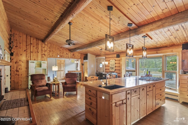 265 Ames Rd, Kenai, AK 99611 - kitchen featuring a sink, a kitchen island with sink, dark wood-style flooring, stainless steel gas cooktop, and pendant lighting