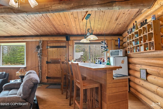 265 Ames Rd, Kenai, AK 99611 - dining room with rustic walls, wooden ceiling, hardwood / wood-style floors, plenty of natural light, and a bar