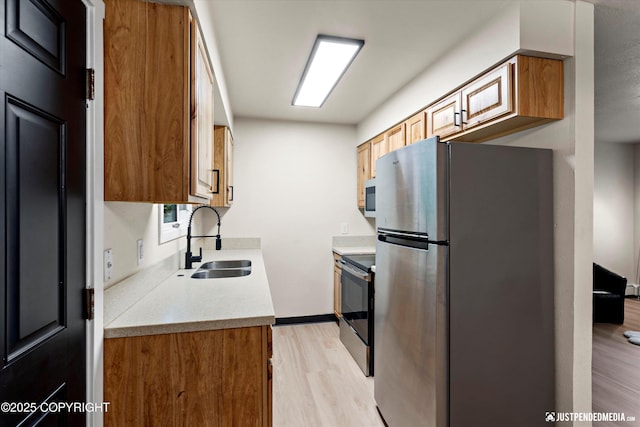 3722 E 19th Ave, Anchorage, AK 99508 - kitchen with appliances with stainless steel finishes, light wood-style flooring, light countertops, and brown cabinetry