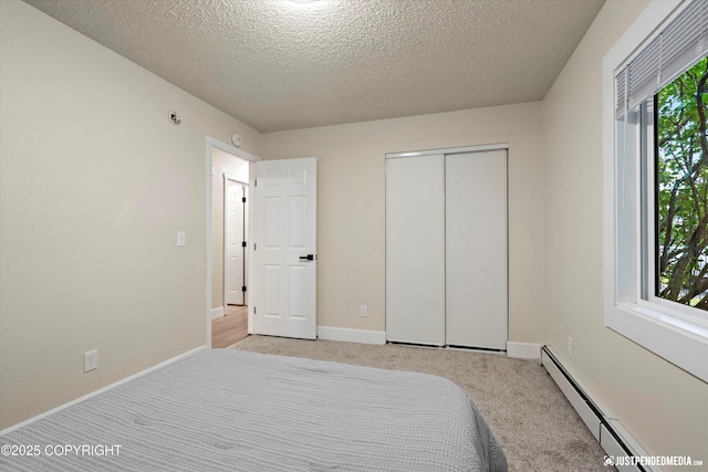 3722 E 19th Ave, Anchorage, AK 99508 - bedroom featuring a baseboard heating unit, light colored carpet, a textured ceiling, and a closet
