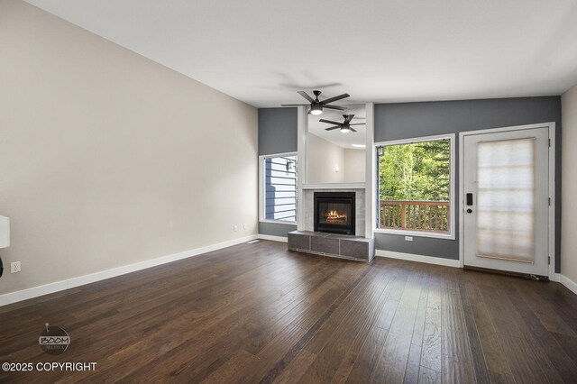 2563 La Honda Dr, Anchorage, AK 99517 - unfurnished living room featuring a ceiling fan, baseboards, wood-type flooring, and a tile fireplace