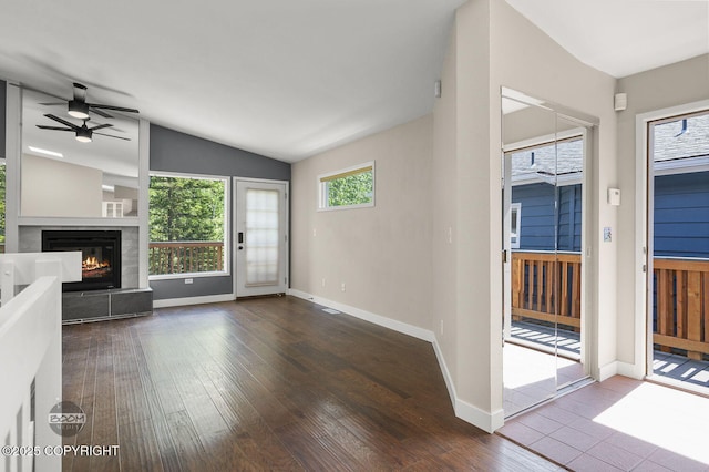 2563 La Honda Dr, Anchorage, AK 99517 - unfurnished living room with ceiling fan, hardwood / wood-style floors, baseboards, a fireplace, and lofted ceiling