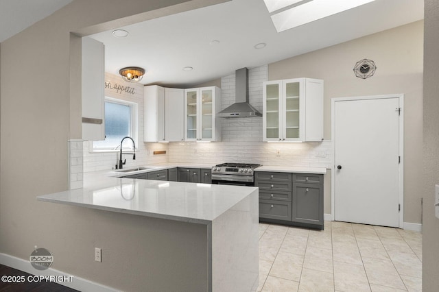 2563 La Honda Dr, Anchorage, AK 99517 - kitchen with wall chimney range hood, gas range, a sink, gray cabinets, and lofted ceiling