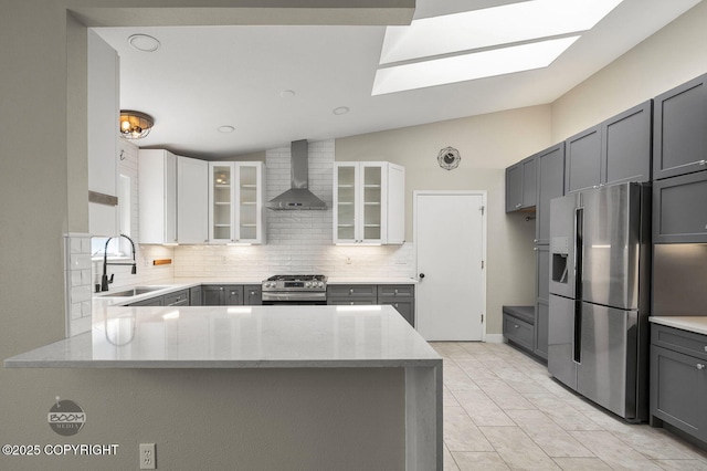 2563 La Honda Dr, Anchorage, AK 99517 - kitchen with stainless steel appliances, a sink, wall chimney exhaust hood, tasteful backsplash, and vaulted ceiling