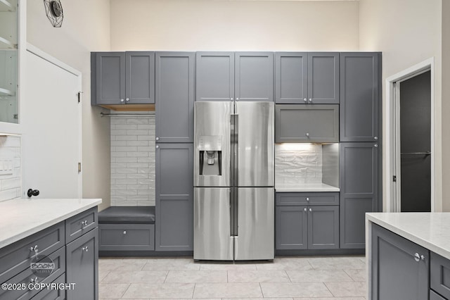 2563 La Honda Dr, Anchorage, AK 99517 - kitchen featuring stainless steel fridge with ice dispenser, gray cabinetry, decorative backsplash, and light tile patterned flooring