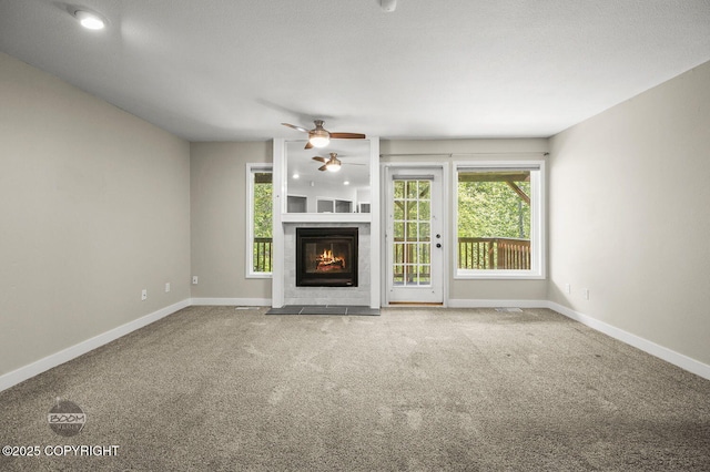 2563 La Honda Dr, Anchorage, AK 99517 - unfurnished living room with a ceiling fan, baseboards, carpet, and a fireplace with flush hearth