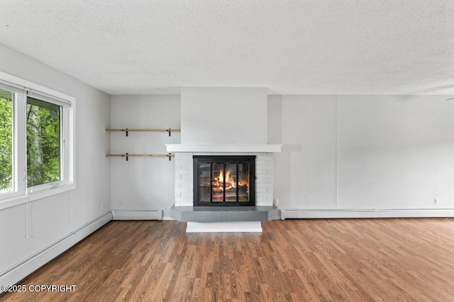 3921 Patricia Ln, Anchorage, AK 99504 - unfurnished living room featuring baseboard heating, a textured ceiling, wood finished floors, and a brick fireplace