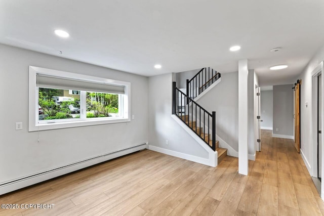 3921 Patricia Ln, Anchorage, AK 99504 - spare room featuring a baseboard heating unit, light wood-style floors, stairs, a barn door, and baseboards