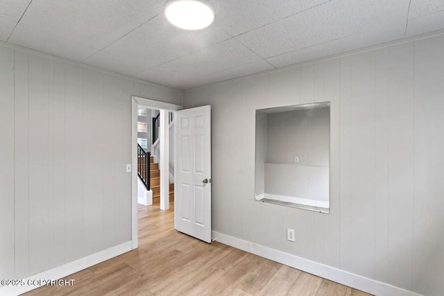 3921 Patricia Ln, Anchorage, AK 99504 - spare room featuring wood finished floors, baseboards, and stairway