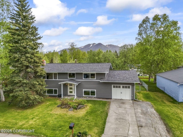3921 Patricia Ln, Anchorage, AK 99504 - view of front of house with a garage, a mountain view, a front yard, and driveway