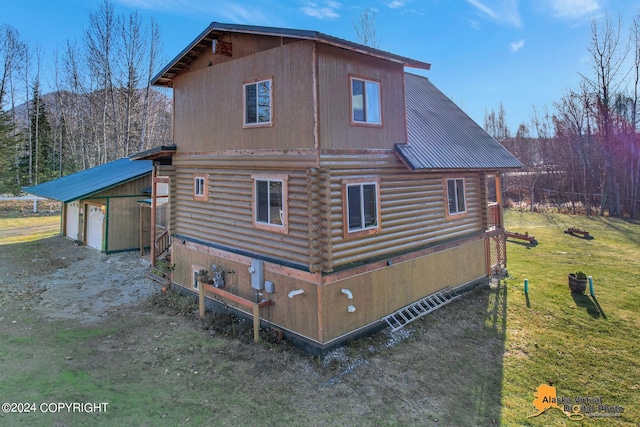19180 Beverly Ave, Chugiak, AK 99567 - view of side of property featuring log exterior, a metal roof, a detached garage, and a lawn