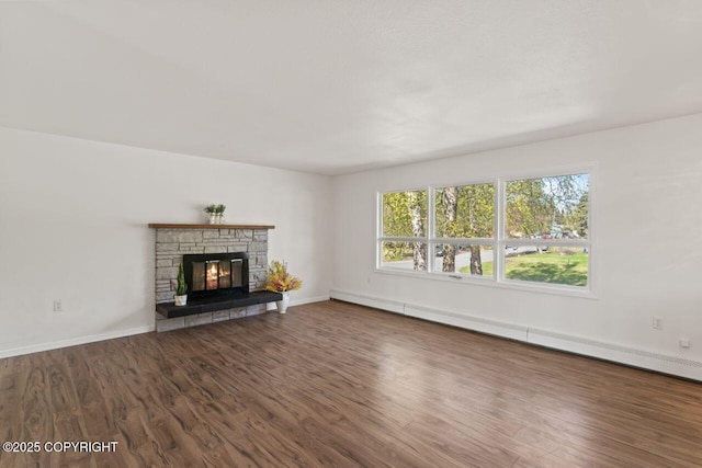 906 Lancaster Dr, Anchorage, AK 99503 - unfurnished living room with wood finished floors, baseboards, a baseboard heating unit, and a stone fireplace