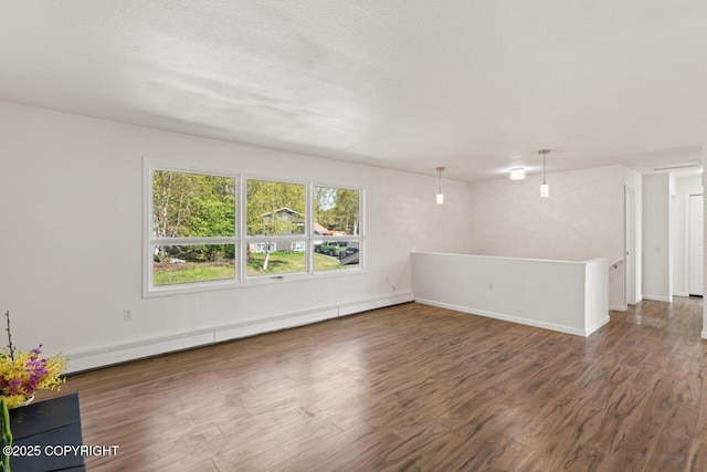 906 Lancaster Dr, Anchorage, AK 99503 - empty room with a baseboard heating unit, wood finished floors, and baseboards