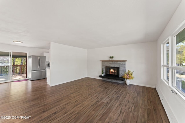 906 Lancaster Dr, Anchorage, AK 99503 - unfurnished living room with plenty of natural light, dark wood finished floors, baseboards, and a stone fireplace