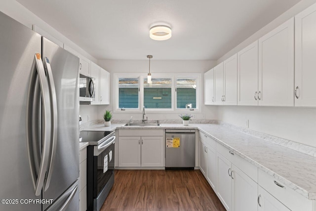 906 Lancaster Dr, Anchorage, AK 99503 - kitchen featuring appliances with stainless steel finishes, a sink, white cabinetry, dark wood-type flooring, and decorative light fixtures