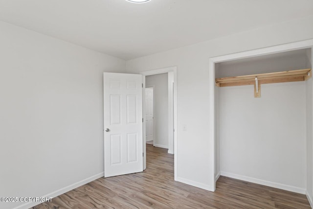 906 Lancaster Dr, Anchorage, AK 99503 - unfurnished bedroom featuring baseboards, wood finished floors, and a closet