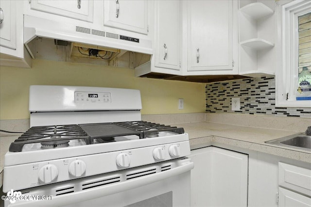 22032 Spring Creek Ln, Chugiak, AK 99567 - kitchen with white gas stove, under cabinet range hood, white cabinets, and light countertops
